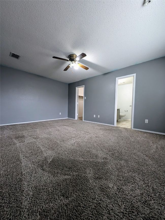 Carpeted spare room with a ceiling fan, baseboards, and a textured ceiling | Image 12