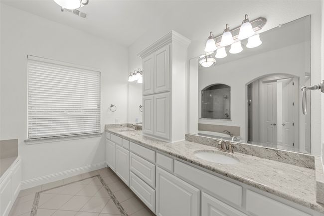 Bathroom with tile patterned flooring, a sink, a bath, and visible vents | Image 19