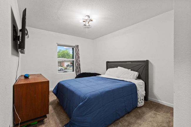 Bedroom featuring carpet floors, baseboards, and a textured ceiling | Image 31