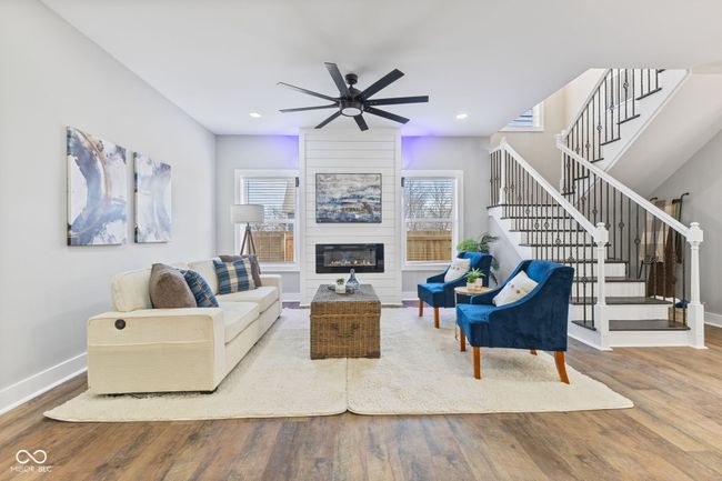 living room with stairway, baseboards, a ceiling fan, and wood finished floors | Image 6