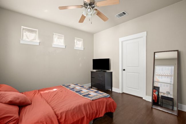 Bedroom featuring visible vents, baseboards, a ceiling fan, and dark wood-style flooring | Image 7