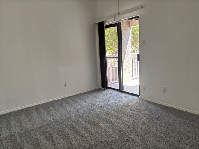 Unfurnished room with dark colored carpet and baseboards | Image 11