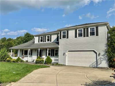 View of front facade with a garage, a porch, and a front lawn | Image 2