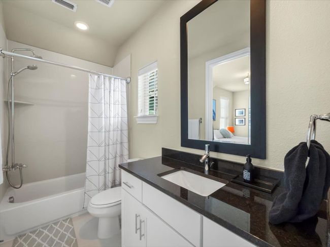 Bathroom featuring shower / bath combo with shower curtain, vanity, toilet, and ensuite bathroom | Image 15