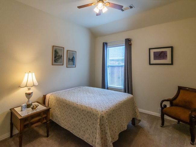 Secondary bedroom with its ceiling fan and elevated ceiling. | Image 31
