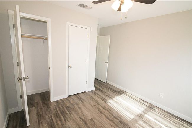 Unfurnished bedroom featuring wood finished floors, a closet, and a ceiling fan | Image 14