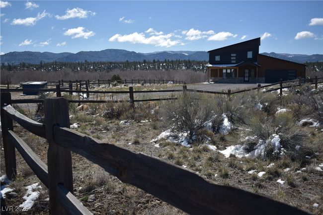 View of yard featuring fence, a mountain view, and a garage | Image 11