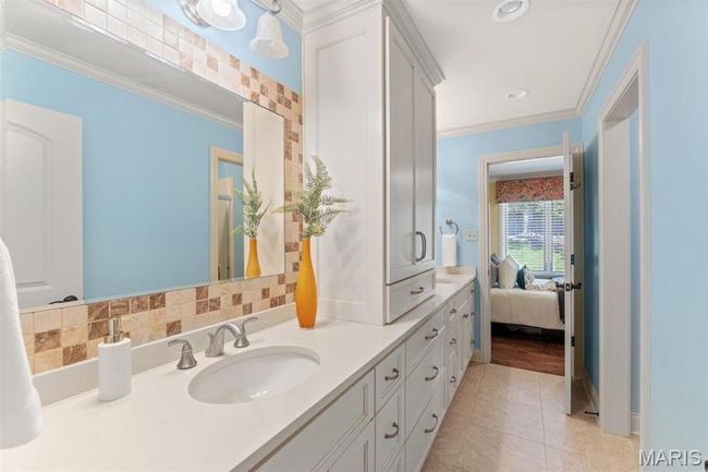 Ensuite bathroom featuring double vanity, crown molding, tile patterned floors, and recessed lighting | Image 28