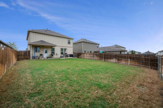 Rear view of property featuring a fenced backyard, a patio, a shingled roof, and a lawn | Image 20