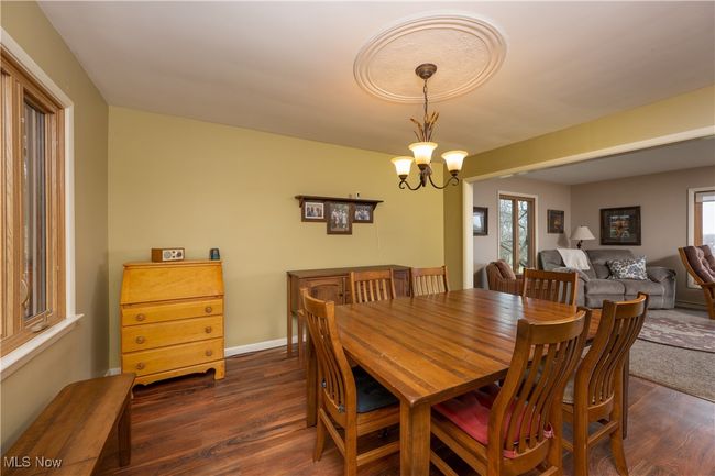 Dining space featuring an inviting chandelier, dark wood-style flooring, and baseboards | Image 24
