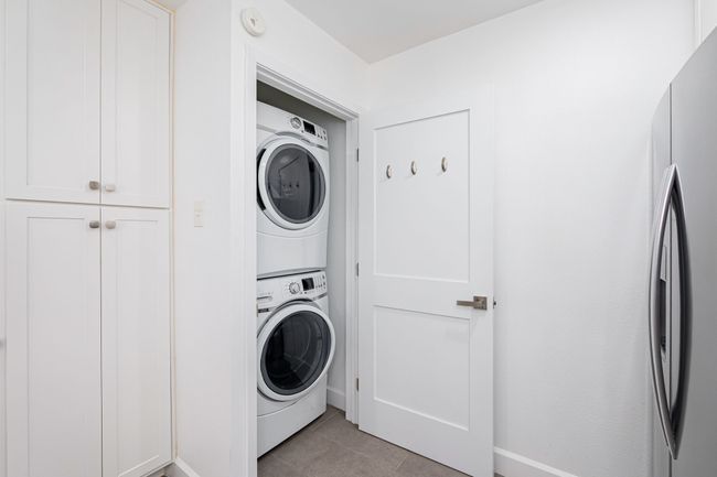 Located in the kitchen, this utility closet has full sized washer & dryer. | Image 23