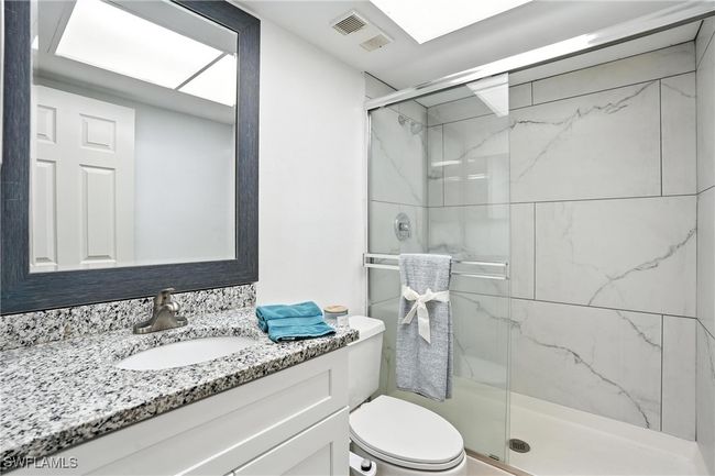 Bathroom with vanity and a marble finish shower | Image 23
