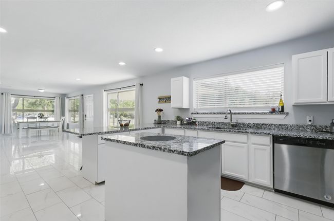 Kitchen with stainless steel dishwasher, a sink, plenty of natural light, a center island, and recessed lighting | Image 4