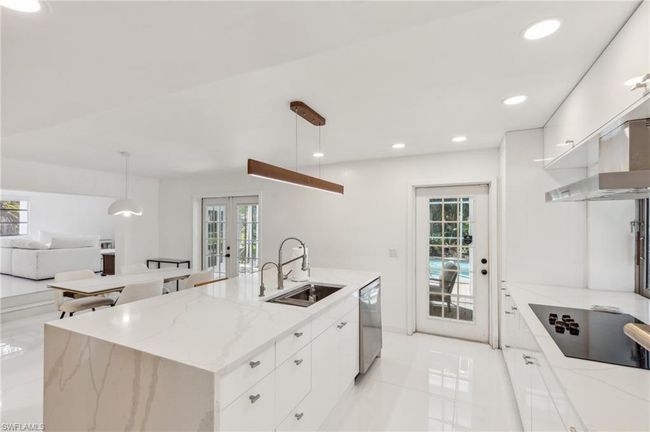 Kitchen with an island with sink, electric stovetop, french doors, a sink, and dishwasher | Image 7