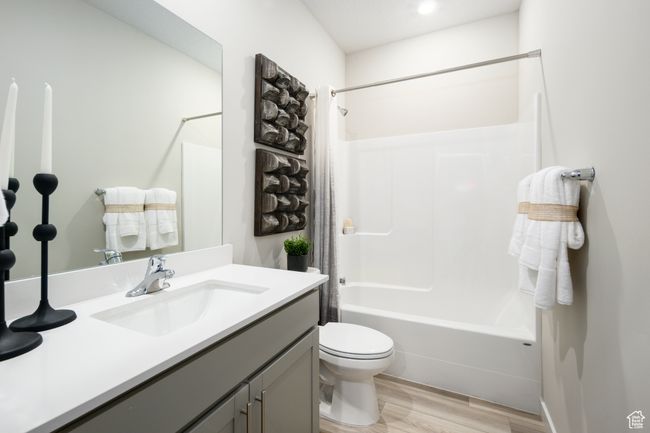 Bathroom with wood finished floors, vanity, toilet, and shower / bath combo | Image 17