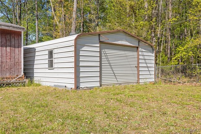 Garage featuring fence and a storage shed | Image 26