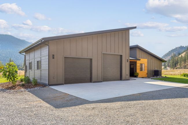 View of front of house featuring a mountain view, concrete driveway, and central air condition unit | Image 8