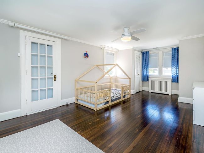 Unfurnished bedroom featuring radiator, wood finished floors, baseboards, and ornamental molding | Image 18