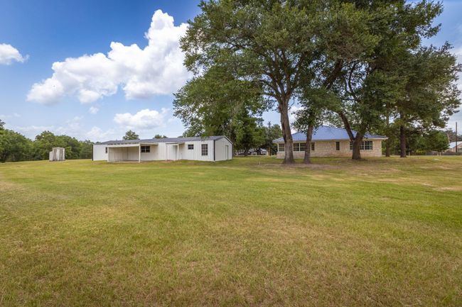 Expansive backyard with mature trees and ample open space, perfect for outdoor activities and relaxation. | Image 38