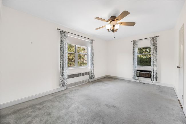 Carpeted spare room with radiator and ceiling fan | Image 17