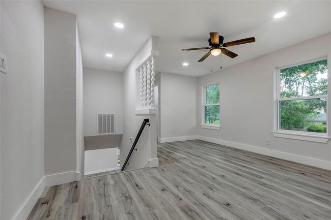 Upstairs game room with large window and ceiling fan. | Image 26