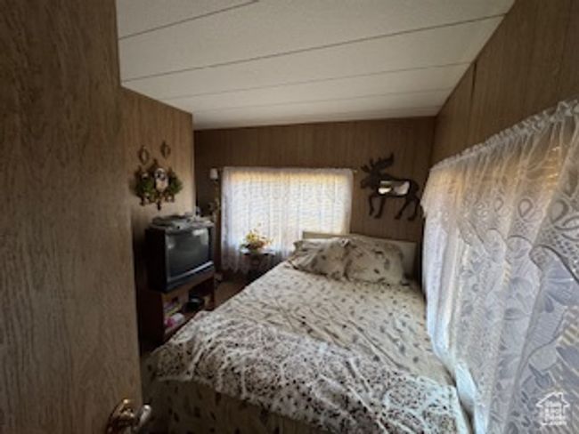 Bedroom featuring wooden walls | Image 7