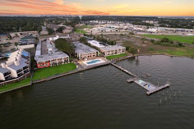 Arial view of condo, peer, pool, and lawn with sitting area | Image 2