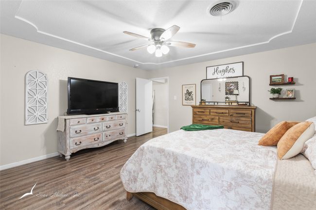 Bedroom with baseboards, ceiling fan, wood finished floors, and visible vents | Image 16