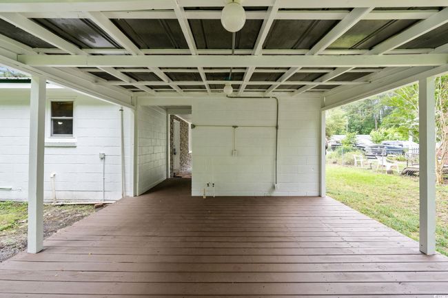 Wooden deck featuring a carport and a yard | Image 10