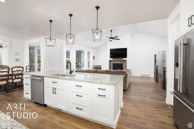 Kitchen featuring white cabinetry, sink, an island with sink, and appliances with stainless steel finishes | Image 14
