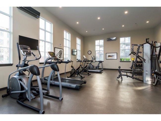 Workout area featuring baseboards, a wall mounted AC, and recessed lighting | Image 19