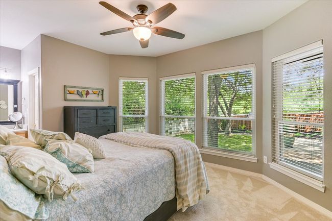 Bedroom with light carpet, multiple windows, baseboards, and ceiling fan | Image 20