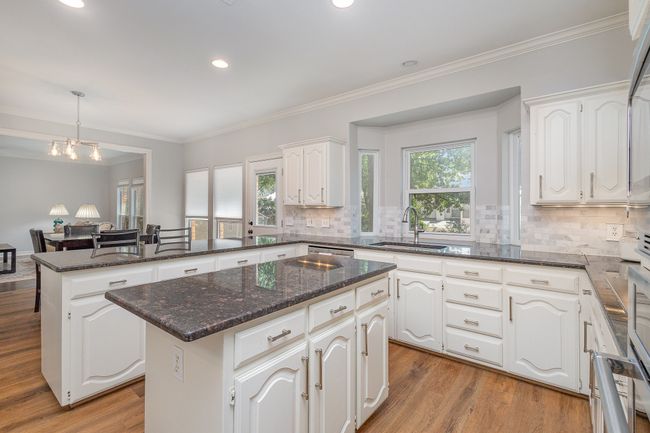 Kitchen with center island, granite countertops, stone backsplash, breakfast bar | Image 9