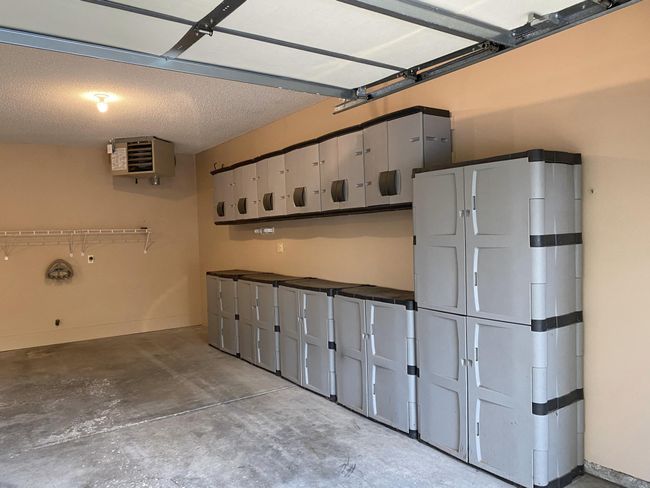 Garage features large storage area with entire wall covered with cabinets. | Image 27