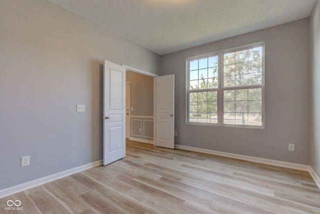 unfurnished bedroom with light wood-style floors and a textured ceiling | Image 18