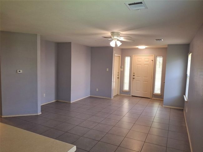 Entryway with a ceiling fan, tile patterned flooring, and baseboards | Image 4