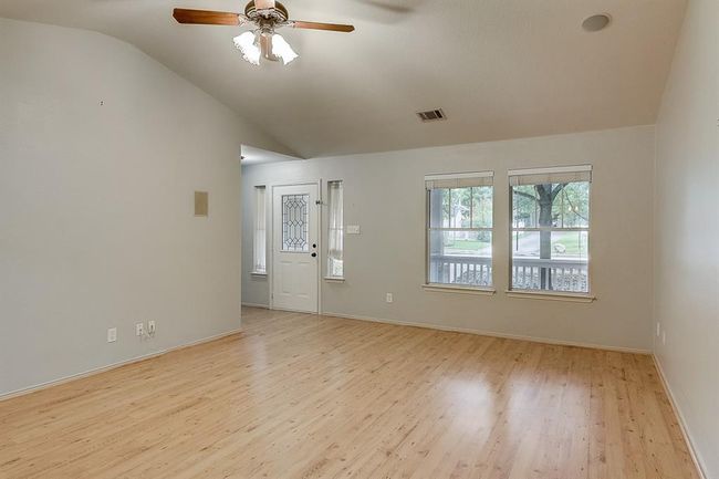 Unfurnished room with vaulted ceiling, light wood-style floors, ceiling fan, and baseboards | Image 5