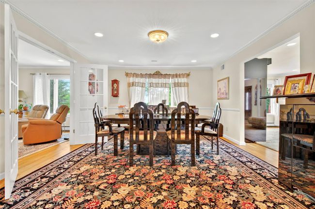 Dining area with plenty of natural light, wood finished floors, crown molding, recessed lighting, and baseboards | Image 10