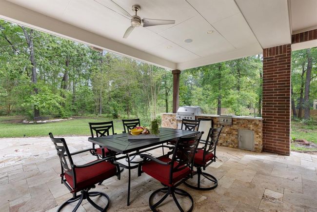 Outdoor kitchen offers grill, refrigerator, burners, and storage cabinet. | Image 35