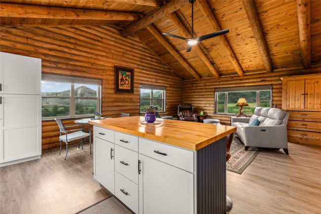Kitchen with wooden counters, rustic walls, wood ceiling, plenty of natural light, and open floor plan | Image 11
