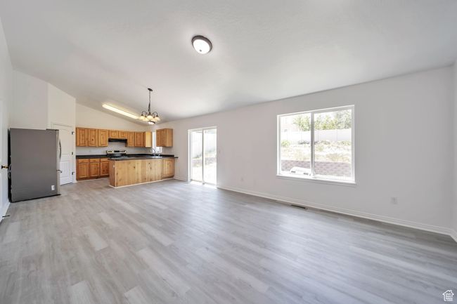 Living area with a chandelier, lofted ceiling, plenty of natural light, LVP floors | Image 6
