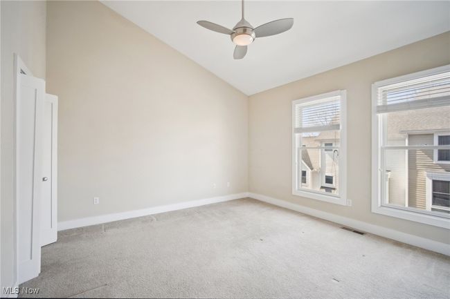 Unfurnished room with visible vents, baseboards, ceiling fan, light colored carpet, and lofted ceiling | Image 21