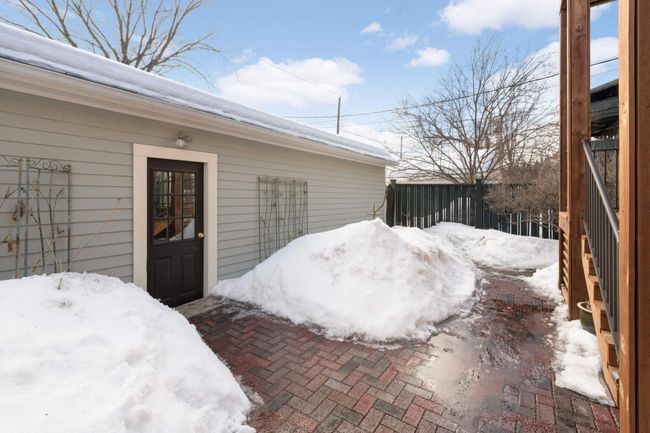 Beyond the deck, a lovely brick courtyard offers more space for relaxing and leads to a 5-stall shared garage with new doors and automatic openers. | Image 26