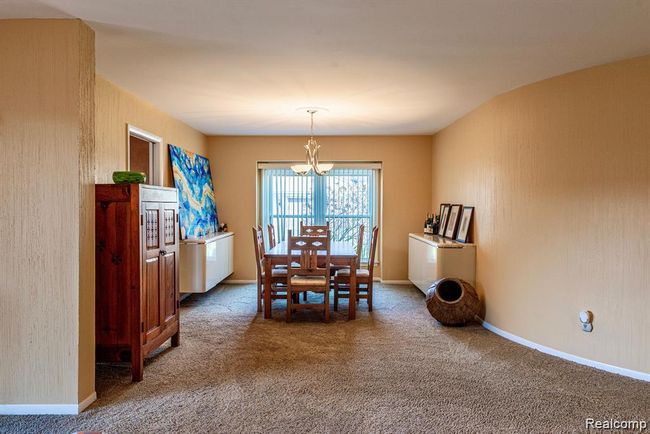 Dining room with a chandelier and carpet floors | Image 13