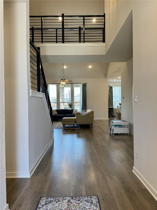 Hallway with baseboards, plenty of natural light, a high ceiling, dark wood-style floors, and recessed lighting | Image 20
