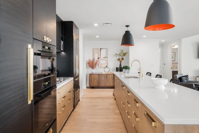Stunning open kitchen featuring built-in Miele appliances, a gas cooktop, wine fridge, all overlooking the downtown views. | Image 4