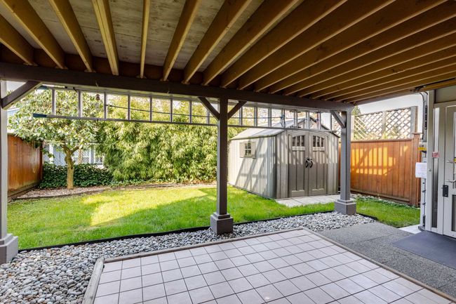 View of patio with a storage unit, a fenced backyard, and an outdoor structure | Image 11