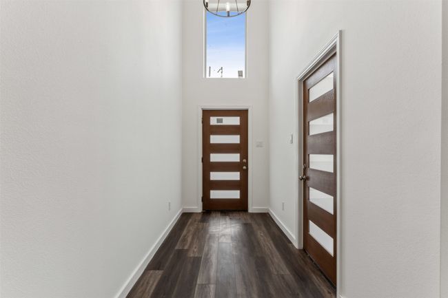 Foyer entrance with dark wood-style floors and a chandelier | Image 10