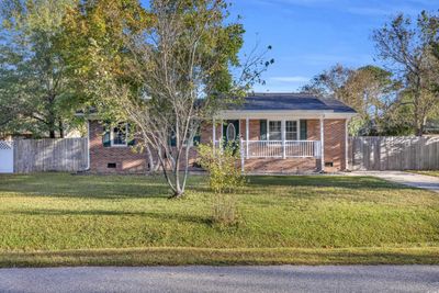 Ranch-style house with a porch and a front lawn | Image 1