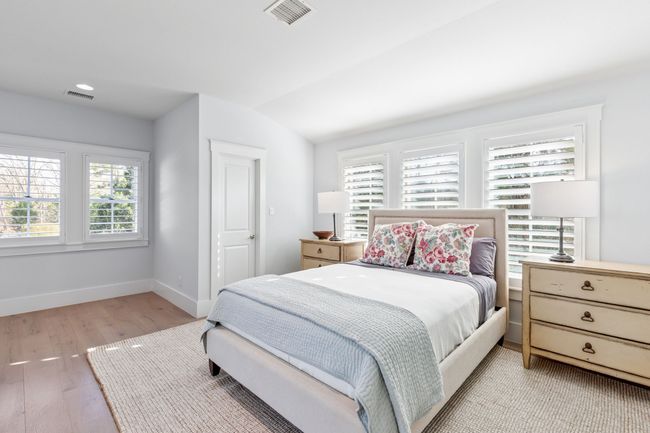 Bedroom with baseboards, visible vents, vaulted ceiling, and light wood finished floors | Image 31